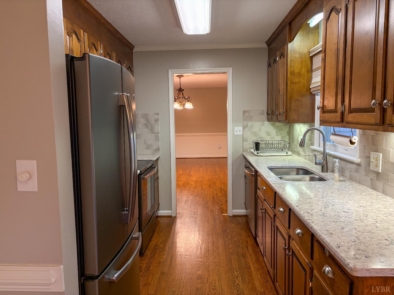 202 Hounds Run Forest, VA 24551 - Photo 14 of 38 a kitchen with stainless steel appliances granite countertop a refrigerator a sink dishwasher a stove and white countertops with wooden floor
