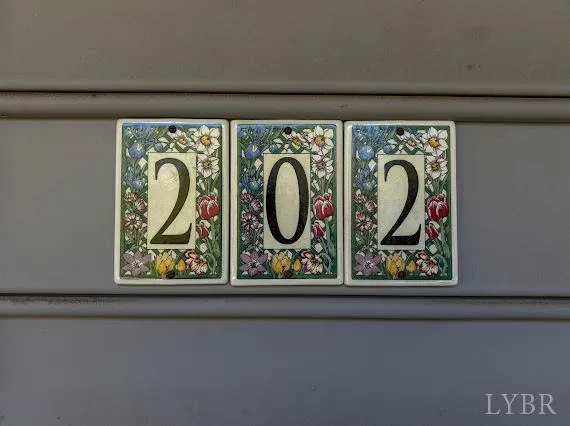 a view of house with backyard and trees in the background