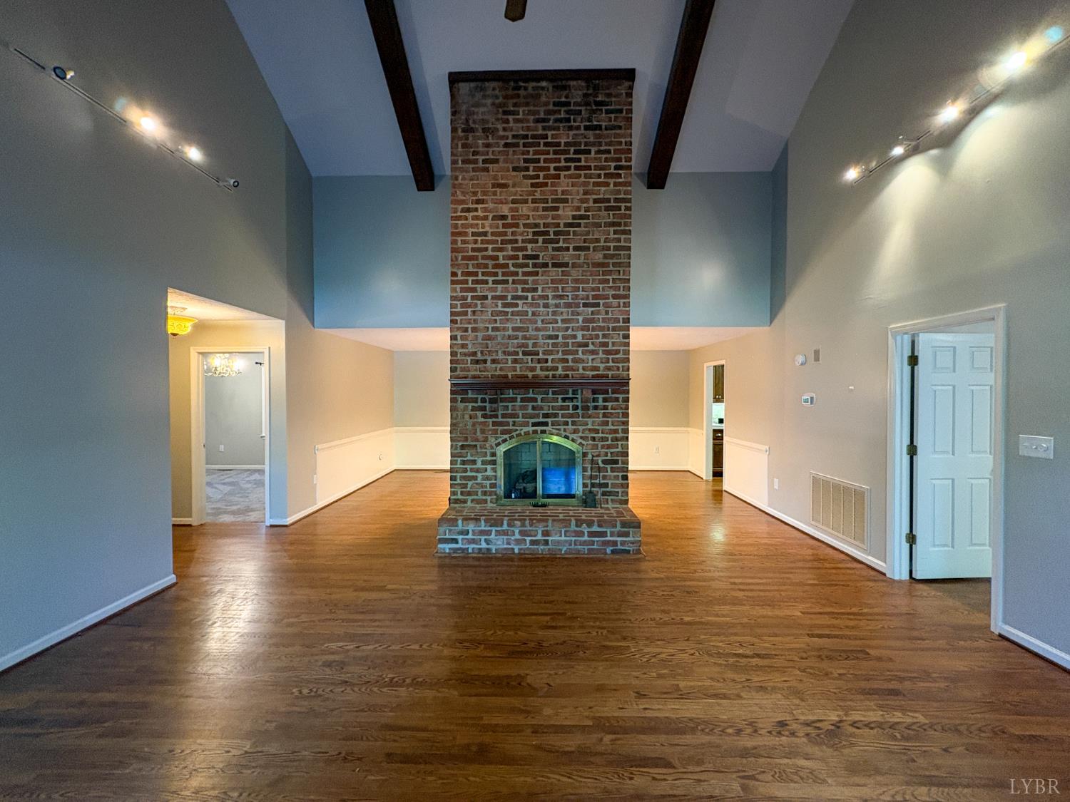 202 Hounds Run Forest, VA 24551 - Photo 4 of 38 a hallway with wooden floor fireplace and windows