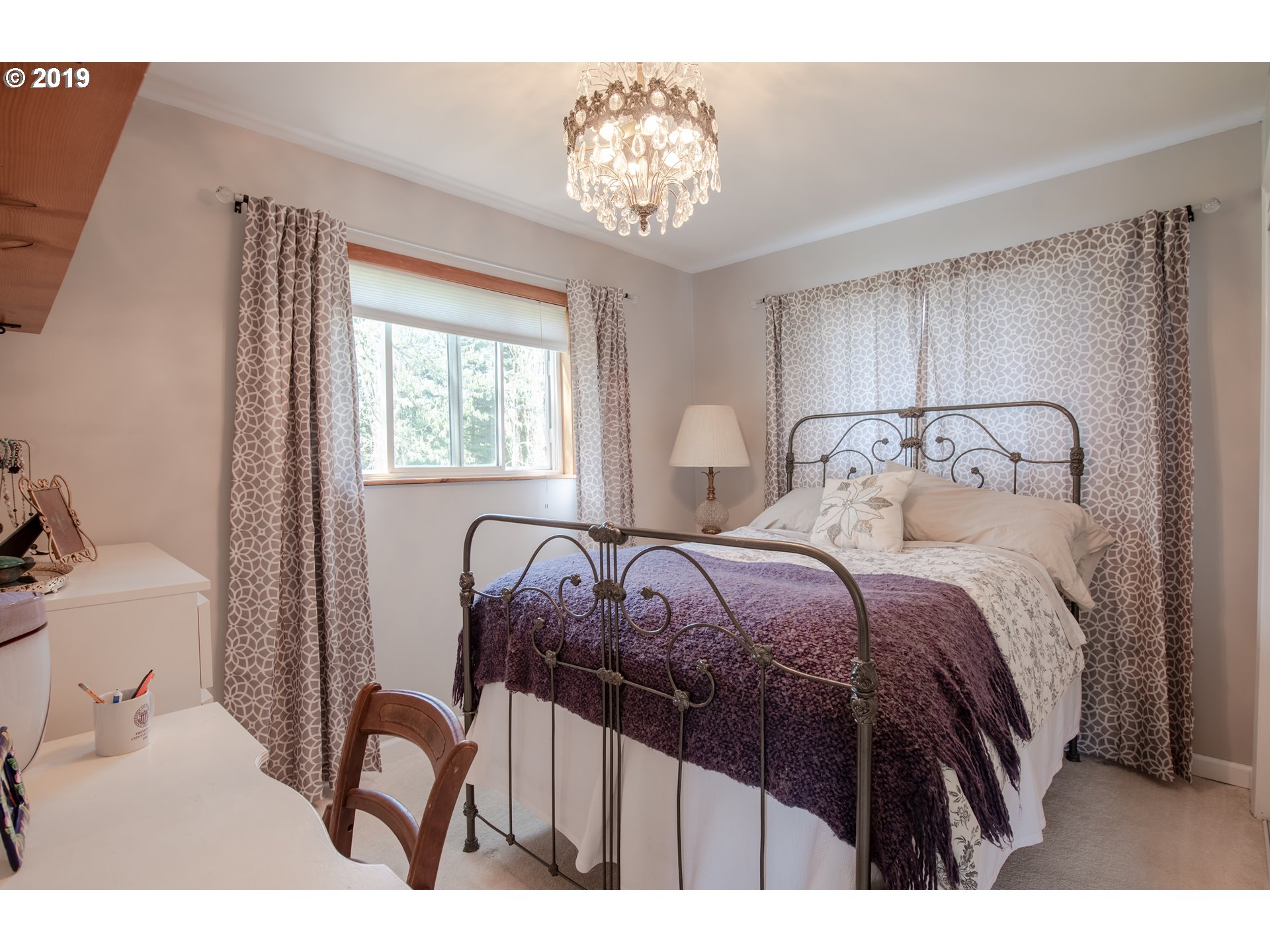 581 Snowden Road White Salmon, WA 98672 - Photo 10 of 27 a bedroom with a bed and a chandelier