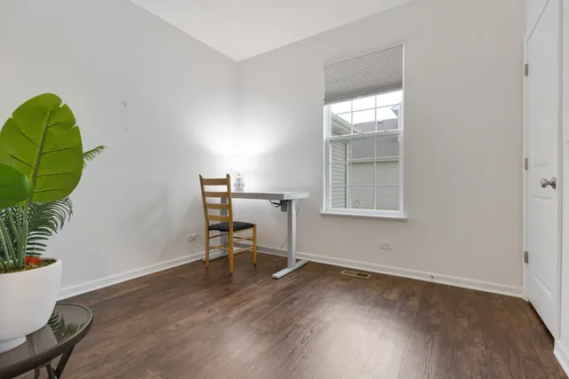 a view of a workspace with wooden floor and a window