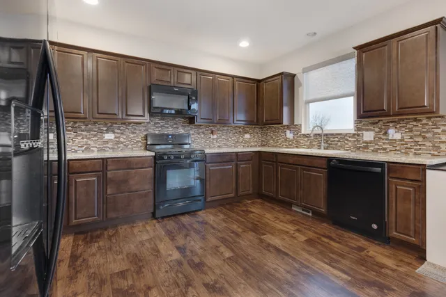 a kitchen with stainless steel appliances granite countertop wooden cabinets granite counter tops and a stove