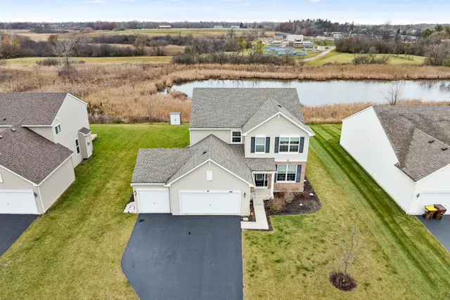 an aerial view of a house with a yard and lake view
