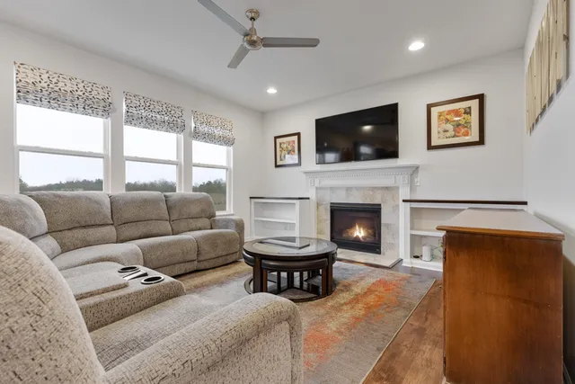 a living room with furniture a flat screen tv and a fireplace