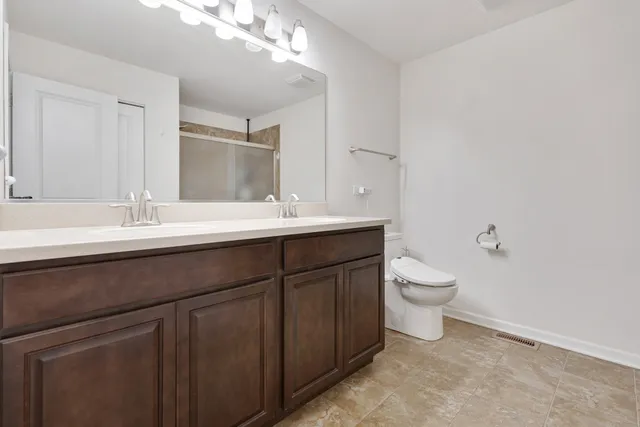 a bathroom with a sink a toilet and mirror