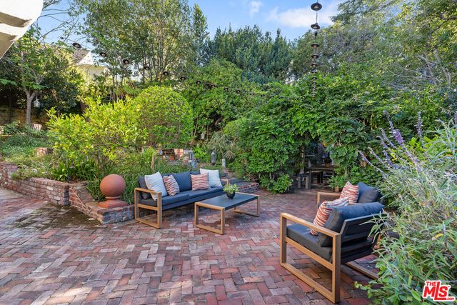 a backyard of a house with fountain table and chairs