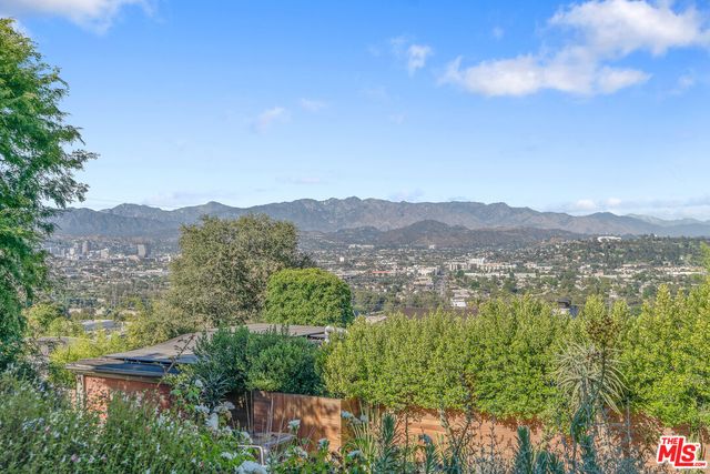 a view of a patio with table and chairs under an umbrella with a small yard