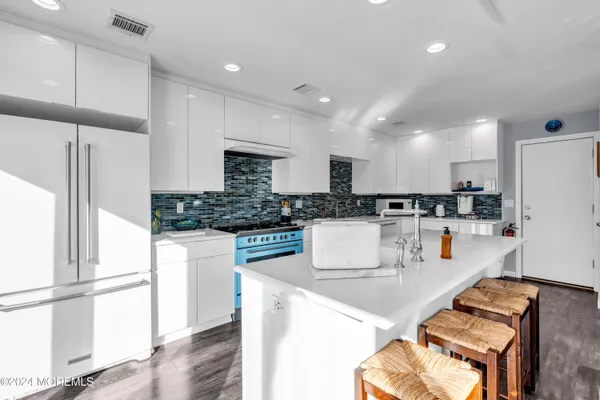a kitchen with stainless steel appliances granite countertop a refrigerator and a stove top oven