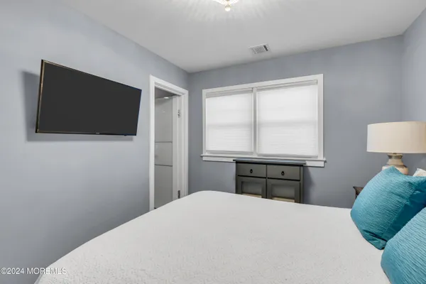 a bedroom with a bed and a flat screen tv