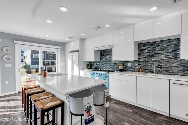 a kitchen with stainless steel appliances kitchen island granite countertop a stove a sink and a refrigerator