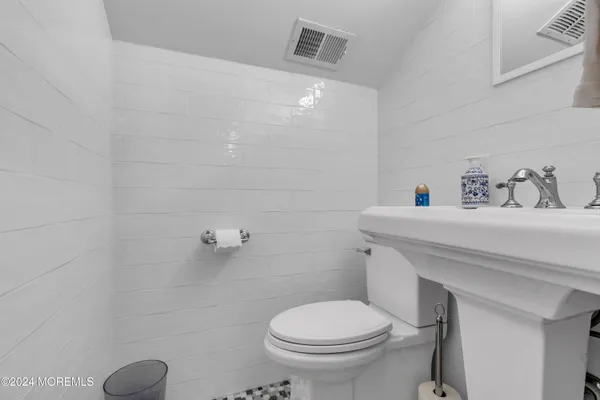 a bathroom with a sink a toilet and a mirror