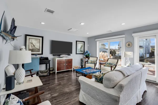 a living room with furniture flat screen tv and couches