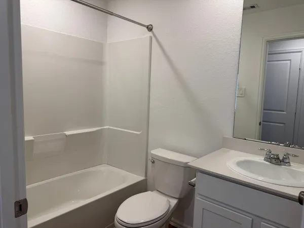a white toilet sitting next to a bath tub