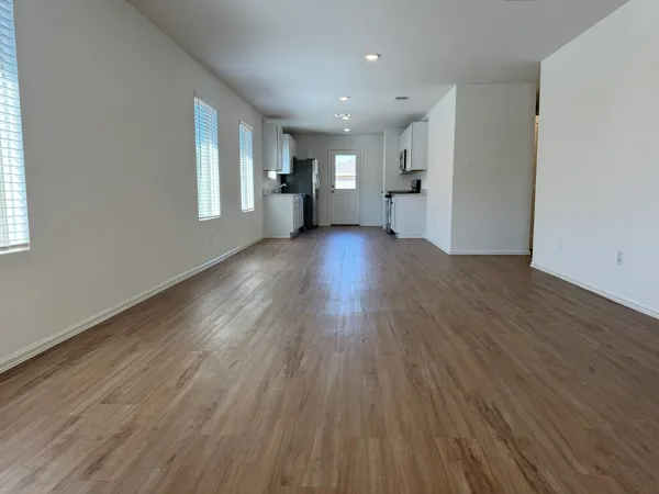 a view of empty room with wooden floor and window