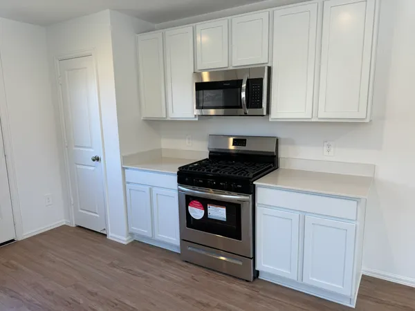 a kitchen with stainless steel appliances a stove a microwave and cabinets