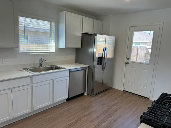 a kitchen with stainless steel appliances granite countertop a refrigerator sink and cabinets