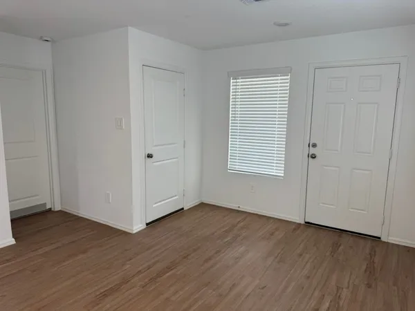 an empty room with wooden floor and windows