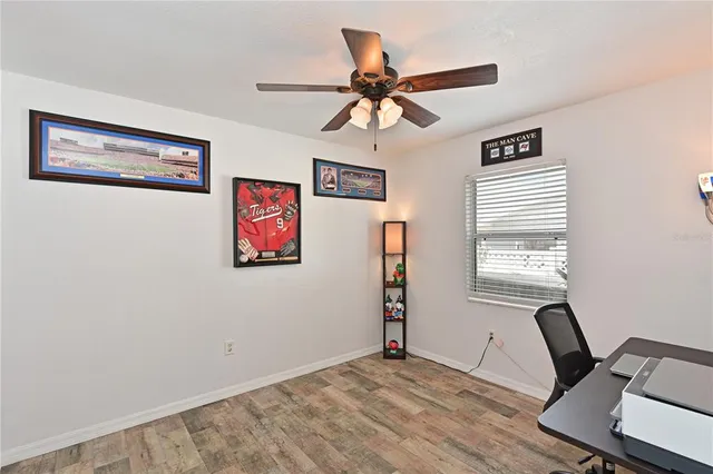 a view of a workspace with wooden floor and a window