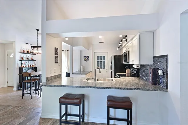a kitchen with granite countertop a table chairs sink and wooden floor