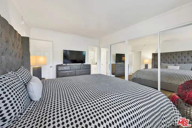 a bedroom with a bed and a flat screen tv