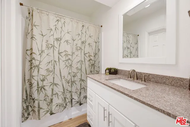 a bathroom with a granite countertop sink and a mirror