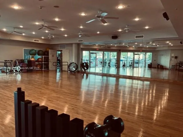 a view of a living room with floor to ceiling window and wooden floor