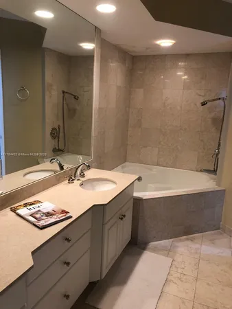 a bathroom with a tub sink and mirror