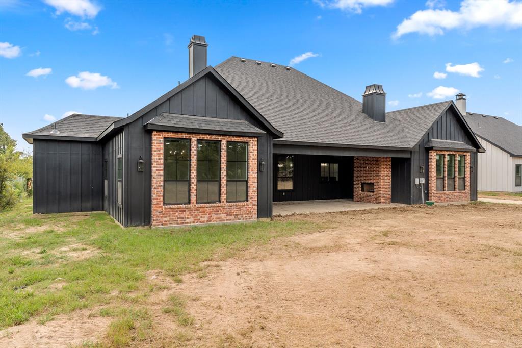 320 Dalton Road Canton, TX 75103 - Photo 23 of 29 Rear view of house featuring a chimney, board and batten siding, a shingled roof, and a patio