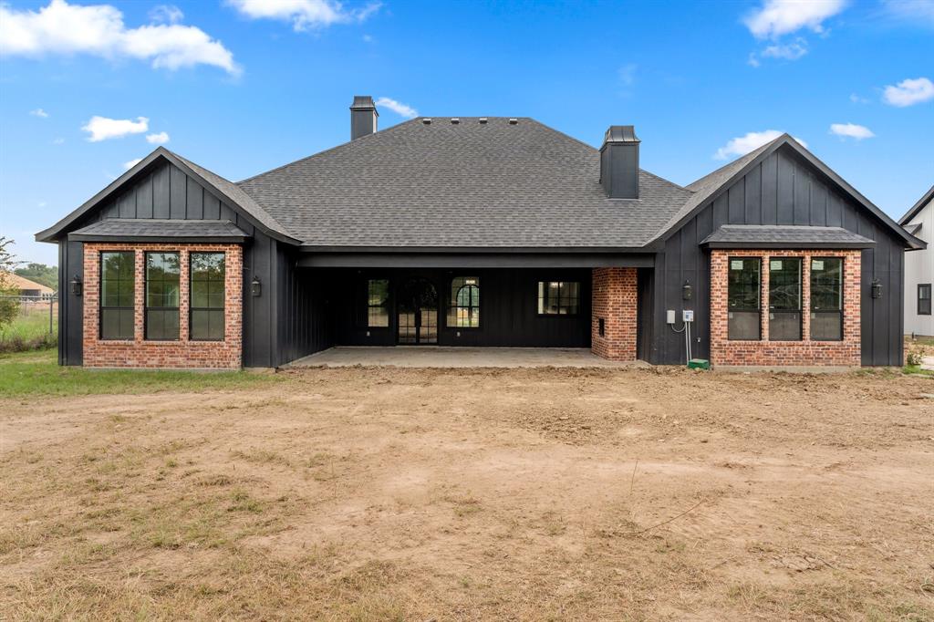 320 Dalton Road Canton, TX 75103 - Photo 25 of 29 Rear view of property featuring board and batten siding, a chimney, a patio, and roof with shingles