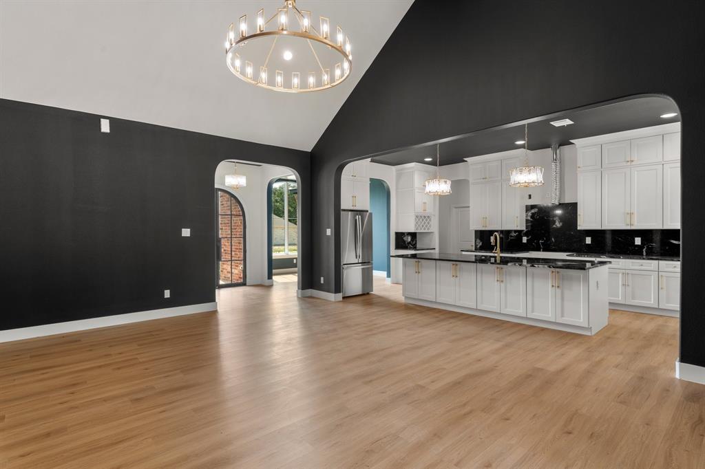 320 Dalton Road Canton, TX 75103 - Photo 27 of 29 Kitchen featuring a chandelier, arched walkways, open floor plan, high vaulted ceiling, and white cabinets