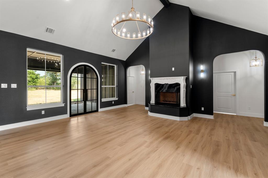 320 Dalton Road Canton, TX 75103 - Photo 6 of 29 Unfurnished living room with a chandelier, a high end fireplace, high vaulted ceiling, light wood-style flooring, and beam ceiling