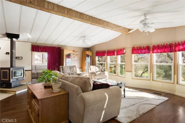 a living room with furniture a flat screen tv and a large window