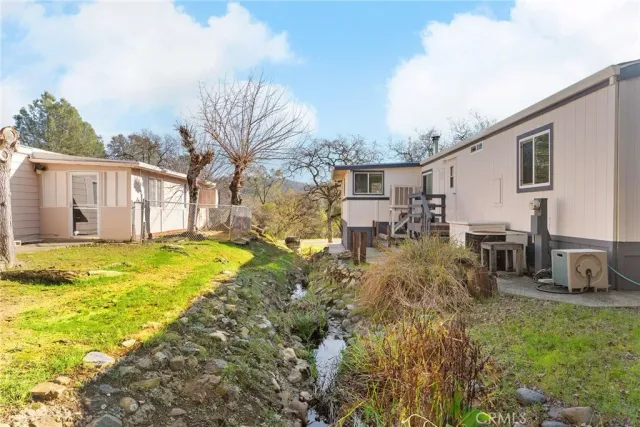 a view of a house with backyard and tree s