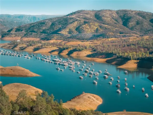 an aerial view of residential houses with outdoor space and lake view
