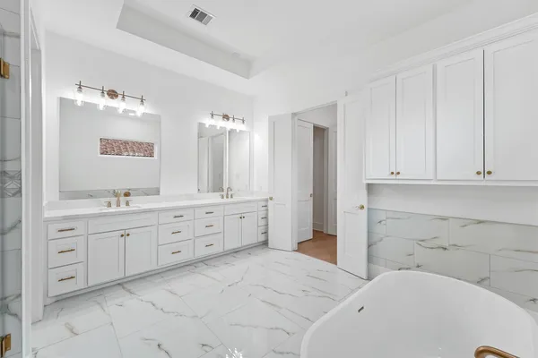 a spacious bathroom with 2 sink tub and a mirror