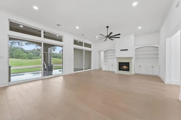 a view of an empty room with a fireplace and a window
