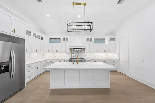 a kitchen with stainless steel appliances a stove refrigerator and cabinets