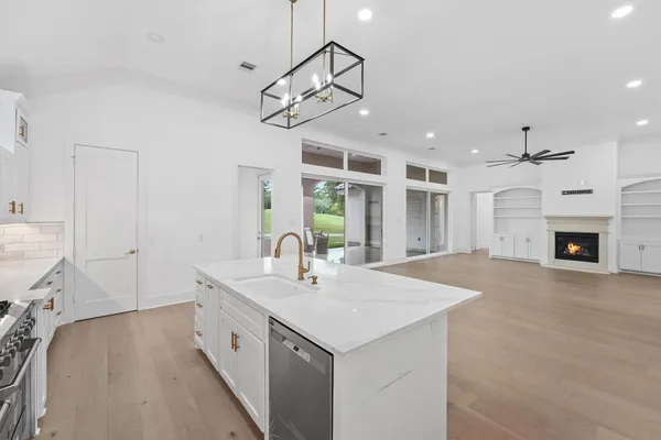 a large white kitchen with a sink a stove and a refrigerator