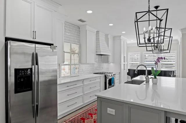 a kitchen with stainless steel appliances a refrigerator sink and cabinets