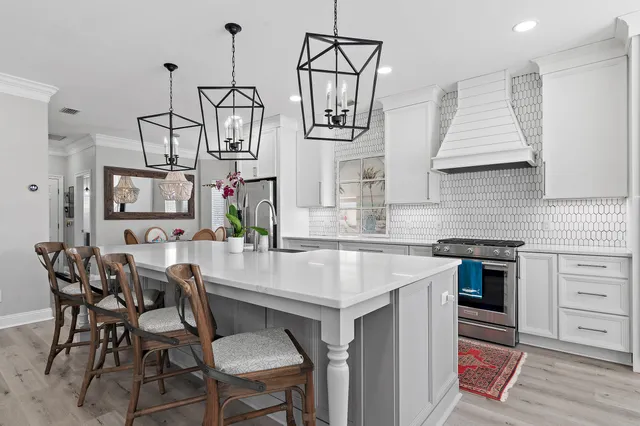 a kitchen that has a table chairs in it and wooden floors