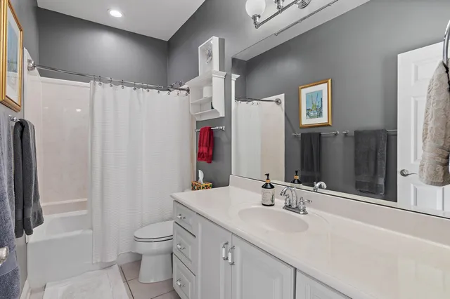 a bathroom with a sink toilet double vanity and shower