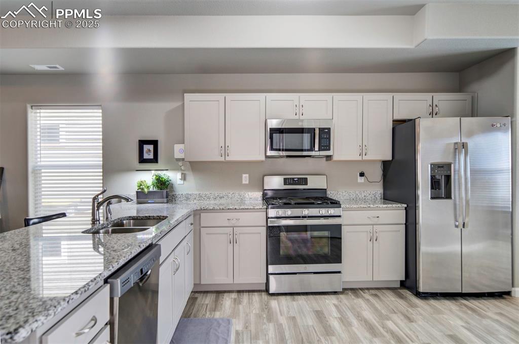 4151 Jericho Loop Colorado Springs, CO 80916 - Photo 11 of 34 a kitchen with a sink a stove a microwave and refrigerator