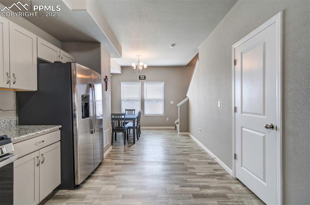 4151 Jericho Loop Colorado Springs, CO 80916 - Photo 14 of 34 a kitchen with white cabinets and stainless steel appliances