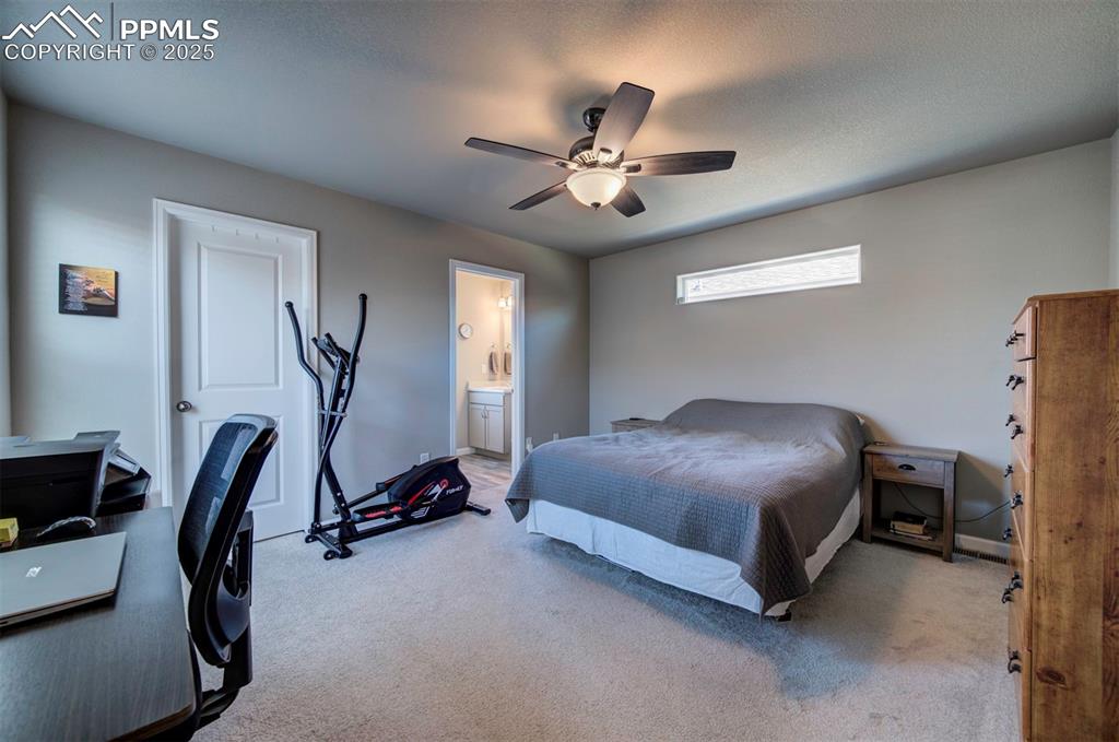 4151 Jericho Loop Colorado Springs, CO 80916 - Photo 20 of 34 a bedroom with a bed and a chandelier