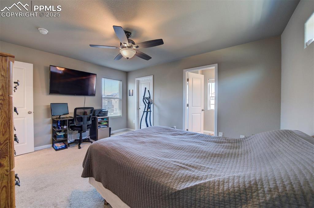 4151 Jericho Loop Colorado Springs, CO 80916 - Photo 22 of 34 a bedroom with a bed a flat screen tv and couches