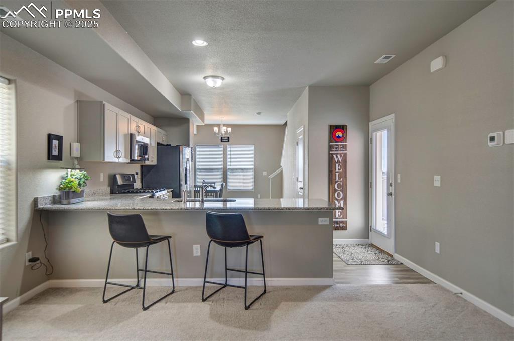 4151 Jericho Loop Colorado Springs, CO 80916 - Photo 8 of 34 a living room with stainless steel appliances furniture a rug and a view of kitchen