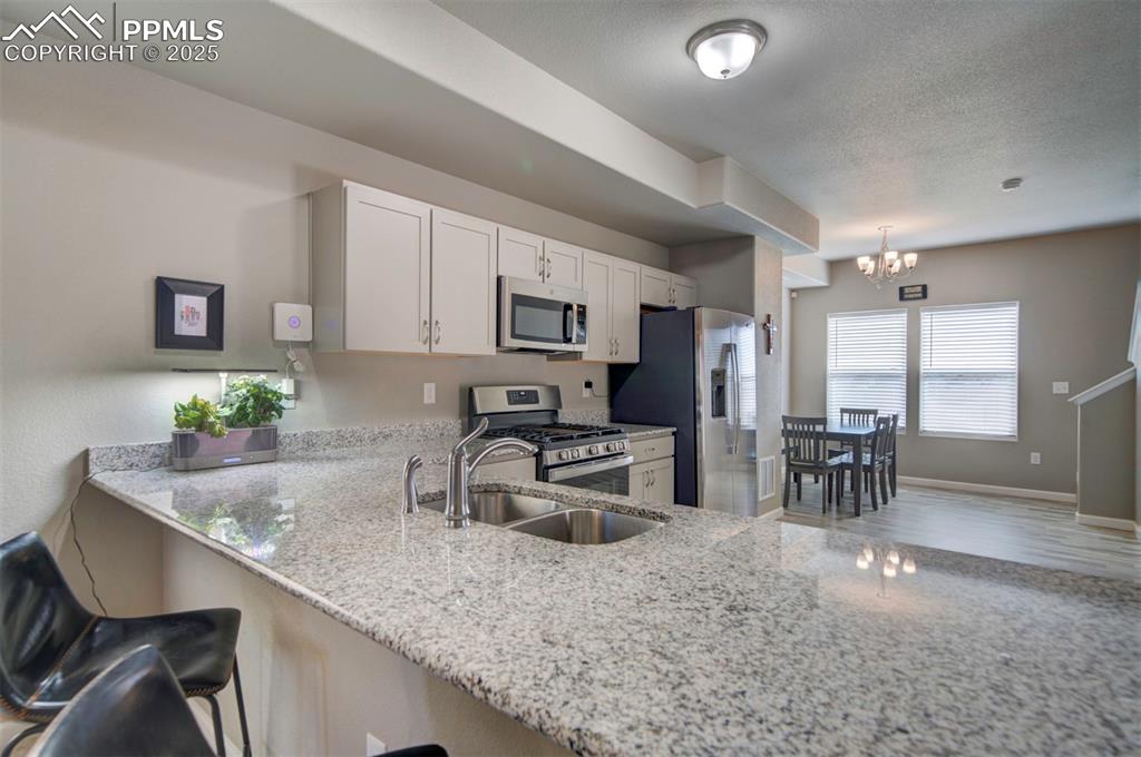 4151 Jericho Loop Colorado Springs, CO 80916 - Photo 10 of 34 a kitchen with counter top space cabinets and stainless steel appliances