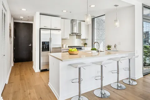 a kitchen with stainless steel appliances kitchen island granite countertop a refrigerator and a sink