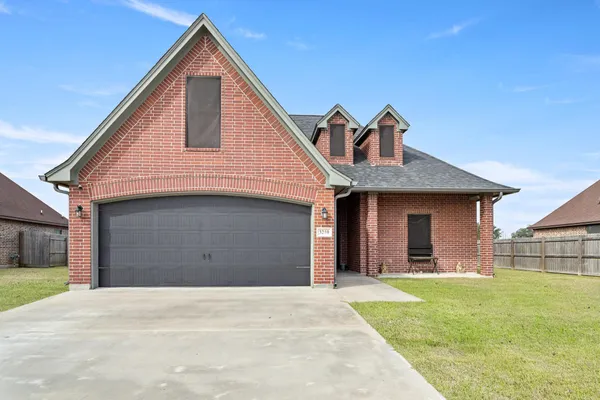a front view of a house with a yard and garage