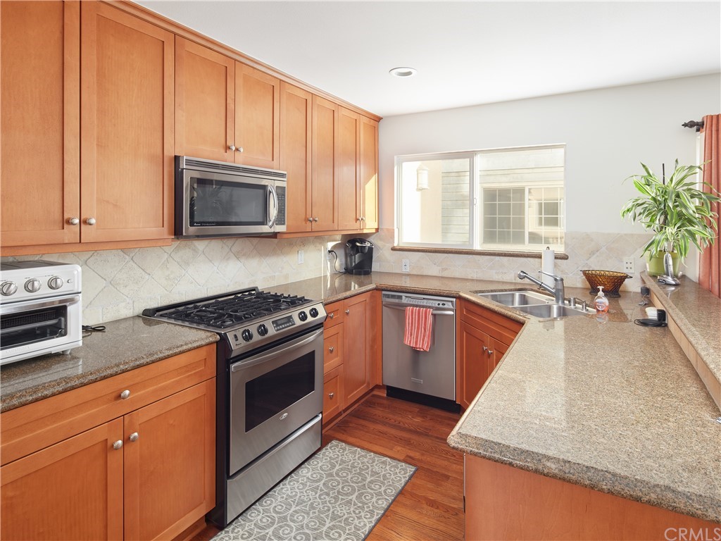 210 Whiting Street, Unit C El Segundo, CA 90245 - Photo 12 of 27 a kitchen with stainless steel appliances granite countertop a stove a sink and a microwave